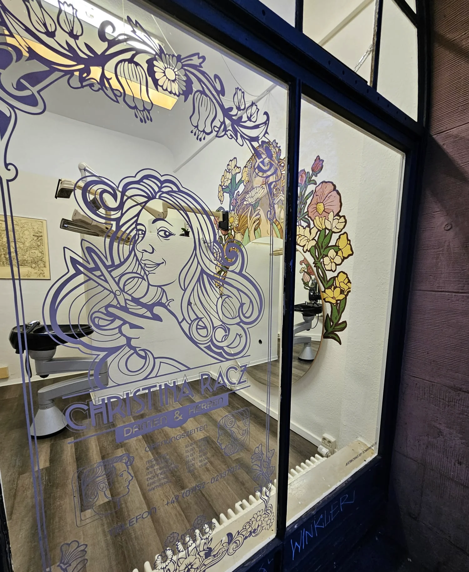 Schaufenster des Salons Christina Racz mit der gezeichneten Friseurinnen-Wortmarke